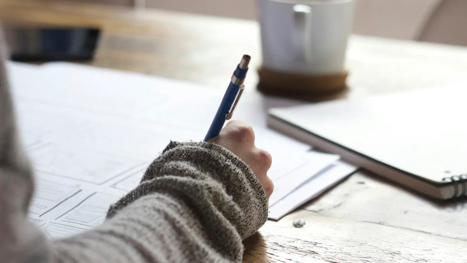 Person writing notes at a desk