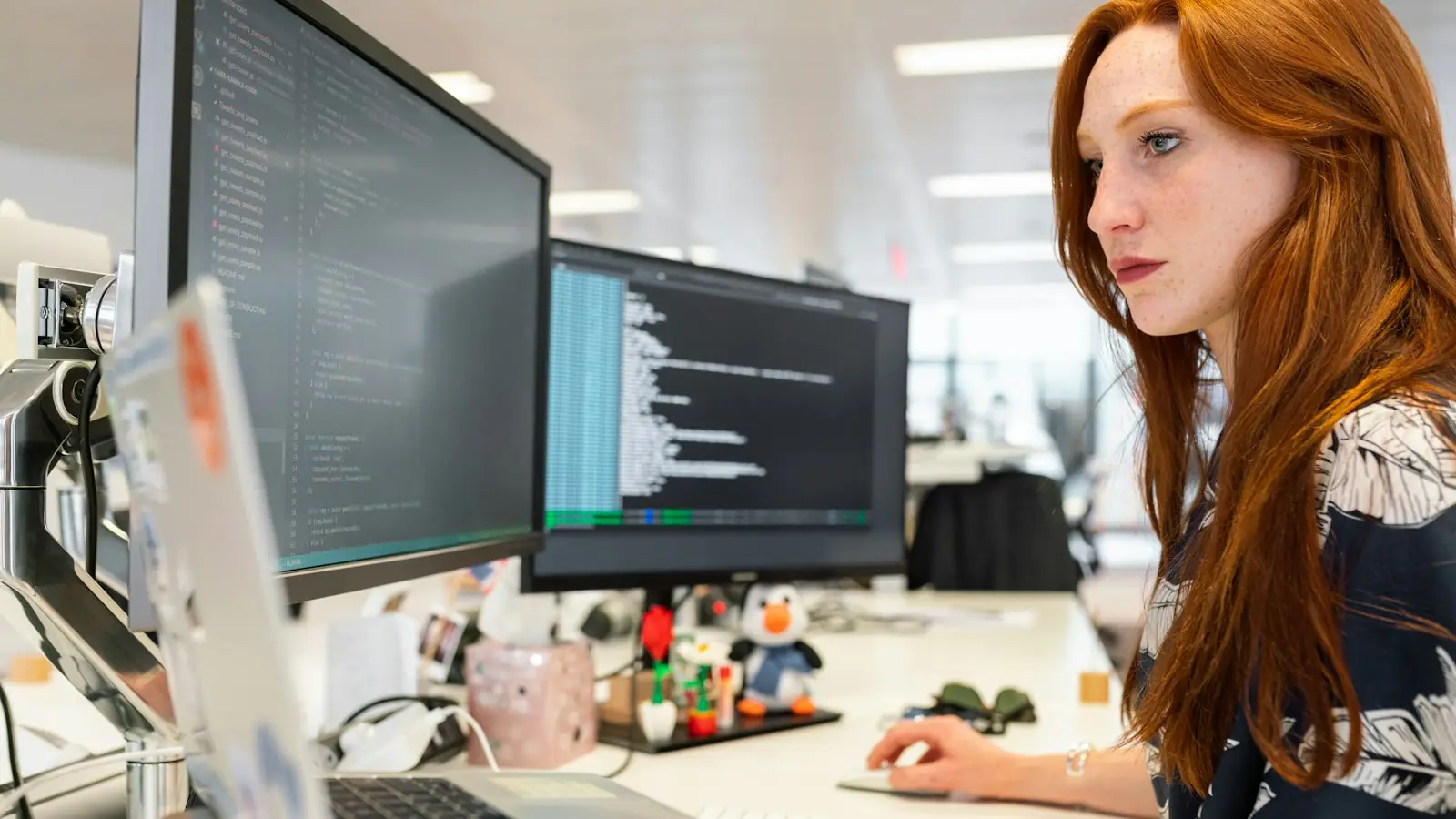 Developer working at a desk with several monitors
