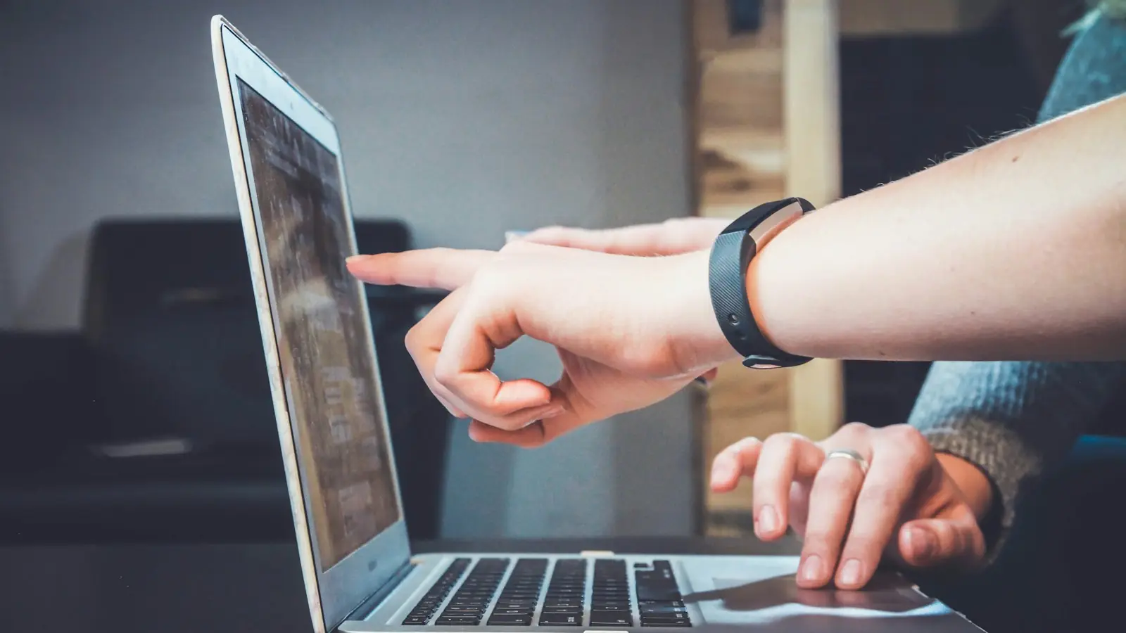 Person pointing at a laptop screen