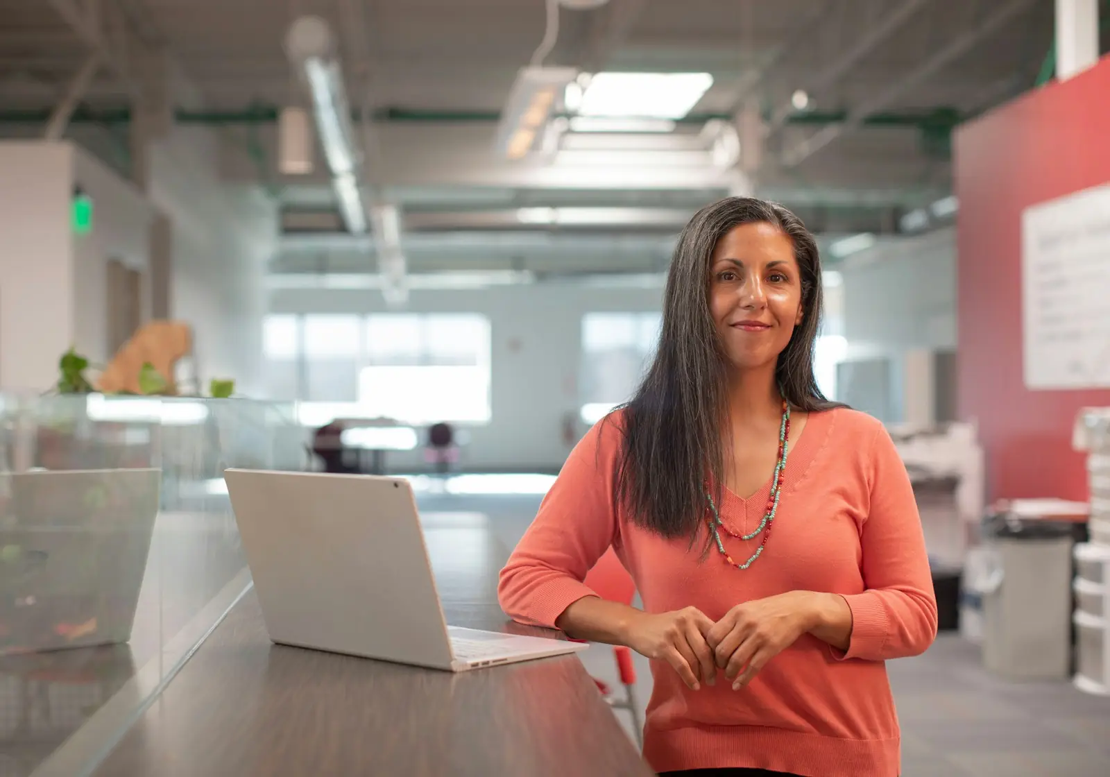 Team lead standing in a bright open-plan office
